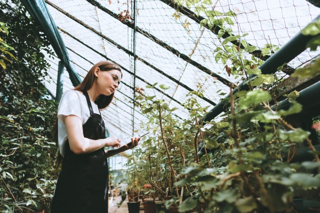 young-woman-gardener-in-glasses-and-apron-with-digital-tablet-working-in-a-garden-center.jpg