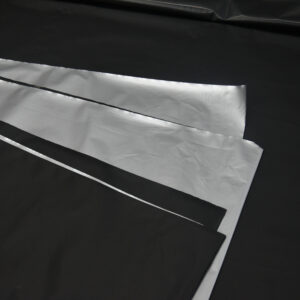 double-sided silver black plastic mulch layers displaying silver top for light reflection and black bottom for weed suppression